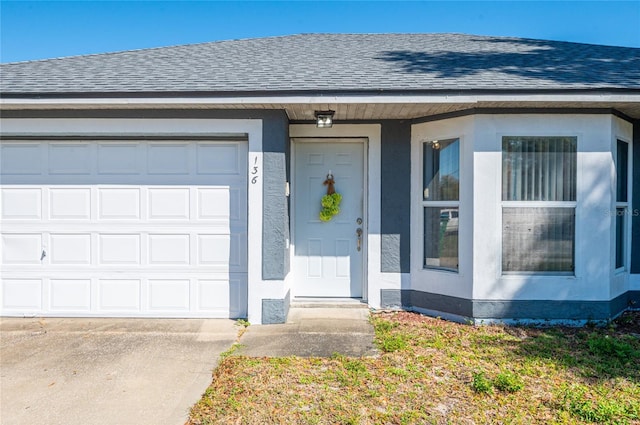 property entrance featuring a garage, stucco siding, driveway, and roof with shingles