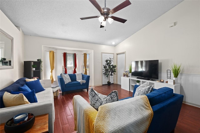 living area with wood finished floors, a wainscoted wall, lofted ceiling, ceiling fan, and a textured ceiling