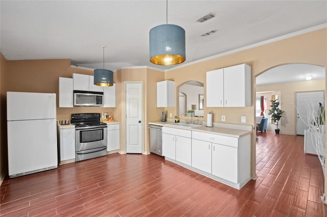 kitchen with arched walkways, appliances with stainless steel finishes, light countertops, and a sink