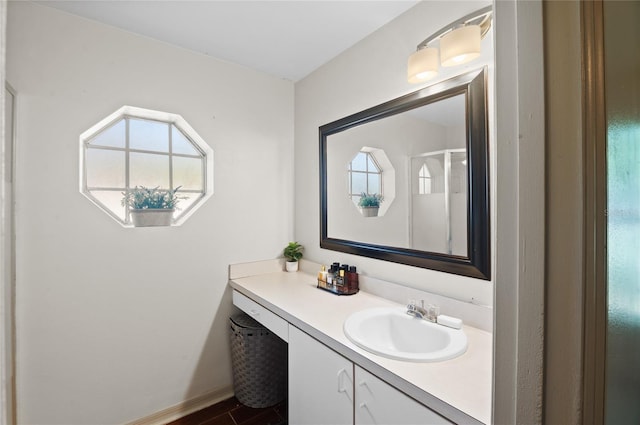 bathroom featuring walk in shower, vanity, and baseboards