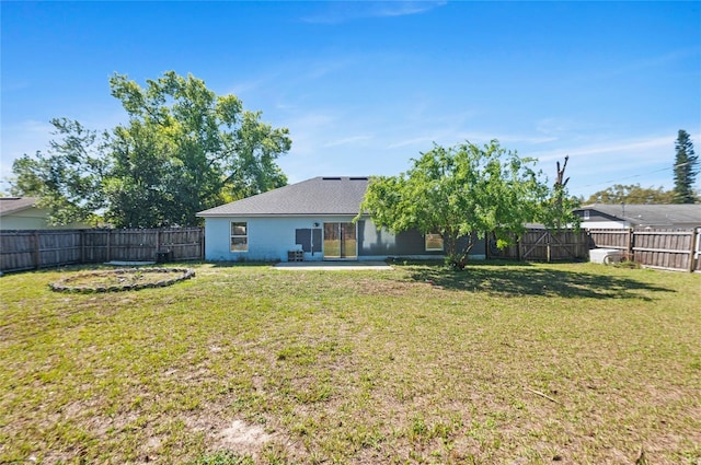 rear view of property with a yard, a patio, and a fenced backyard