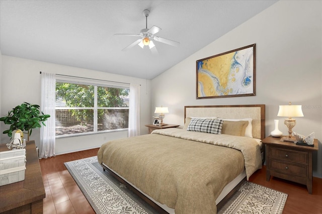 bedroom with ceiling fan, wood finished floors, and vaulted ceiling