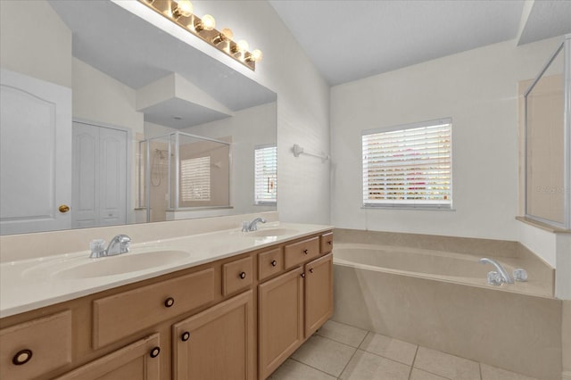 bathroom featuring tile patterned floors, a bath, a stall shower, and a sink