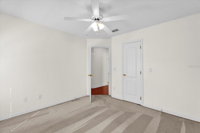 spare room featuring carpet flooring, baseboards, visible vents, and ceiling fan