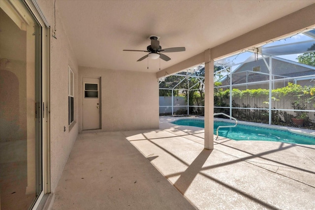 view of pool featuring a ceiling fan, glass enclosure, a patio area, and fence