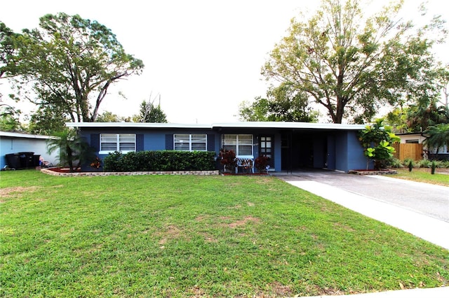 ranch-style house with a front yard, an attached carport, driveway, and fence