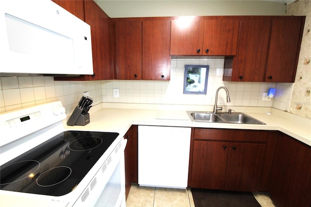 kitchen with white appliances, light countertops, backsplash, and a sink