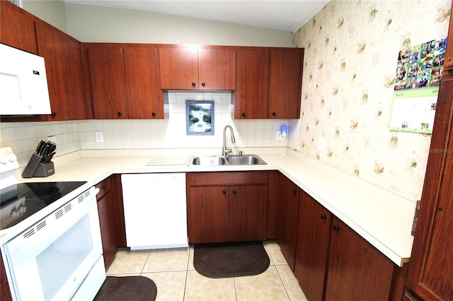 kitchen featuring wallpapered walls, light countertops, light tile patterned flooring, white appliances, and a sink