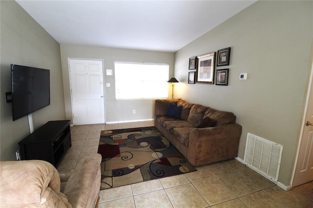 tiled living area with visible vents, baseboards, and lofted ceiling