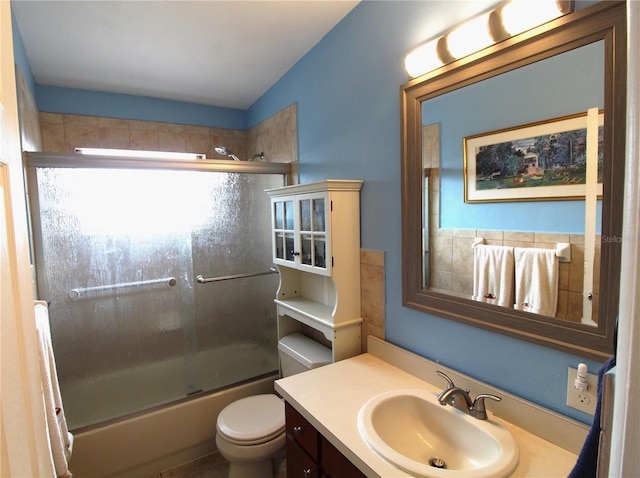 bathroom featuring bath / shower combo with glass door, toilet, and vanity