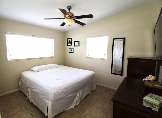 bedroom with tile patterned floors, a ceiling fan, and baseboards