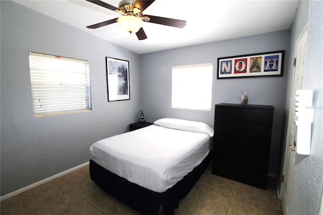 tiled bedroom featuring baseboards and ceiling fan