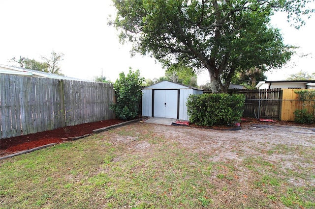 view of yard with a fenced backyard, a storage shed, and an outdoor structure