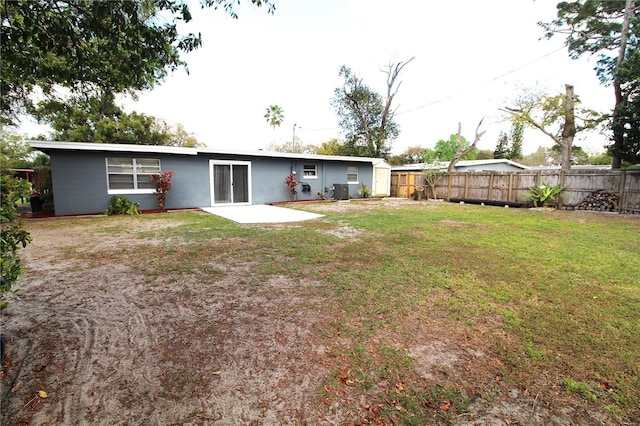 back of property featuring a patio, a yard, and fence