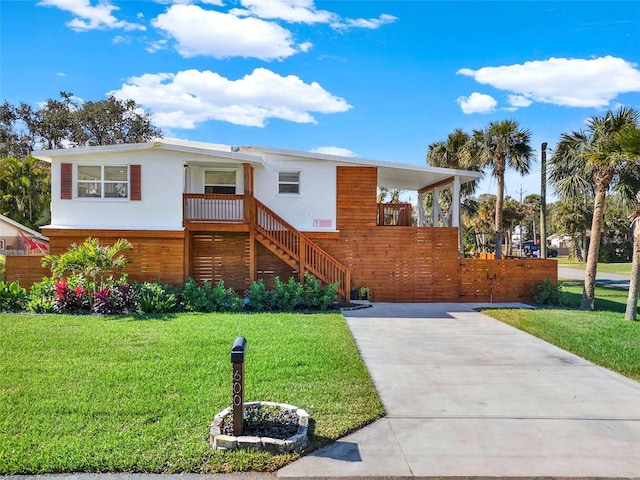 view of front of property with stucco siding, driveway, and a front yard