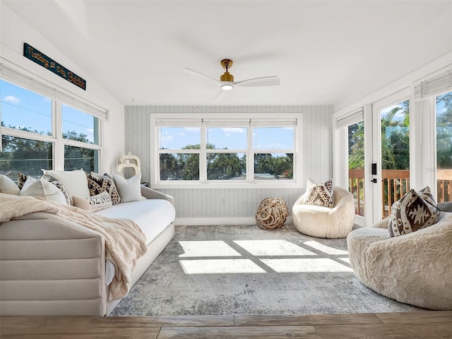 sunroom with lofted ceiling and a ceiling fan