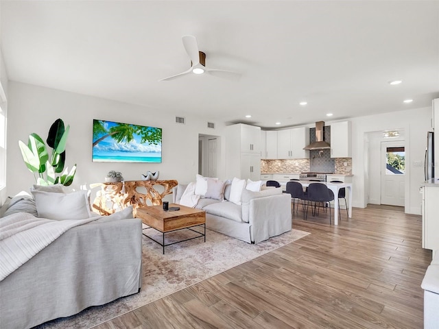 living area with recessed lighting, visible vents, light wood-style floors, and a ceiling fan