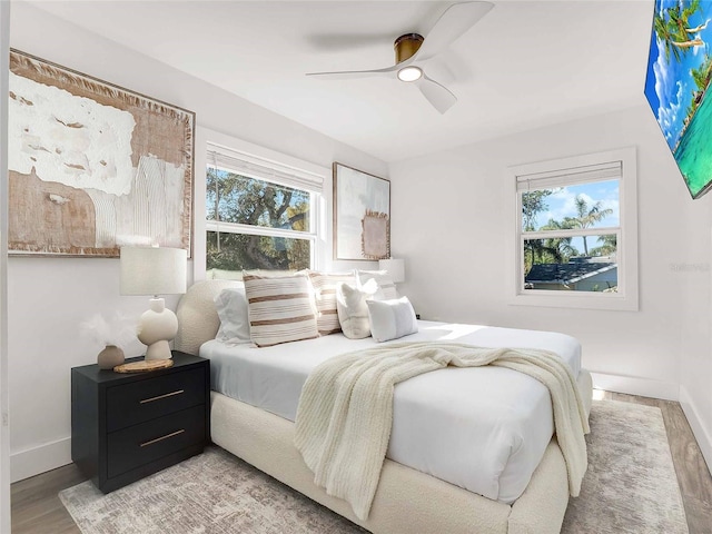 bedroom featuring ceiling fan, baseboards, and wood finished floors