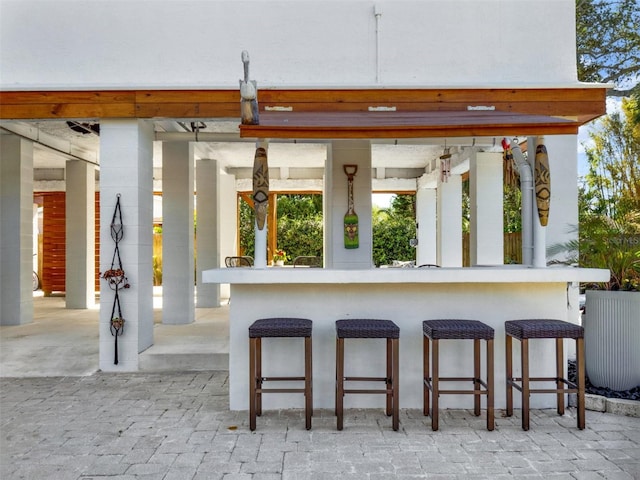 exterior space featuring a breakfast bar and brick floor