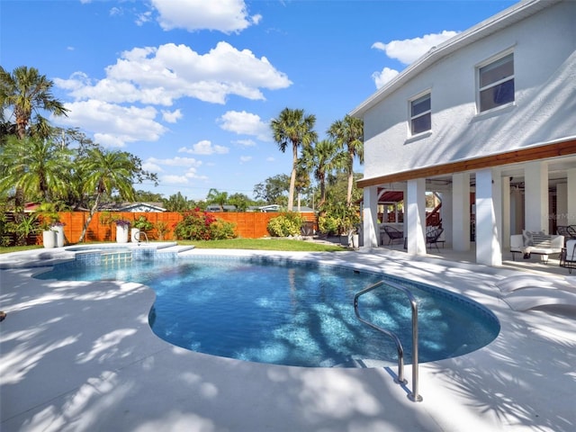 view of pool featuring a pool with connected hot tub, a fenced backyard, and a patio area