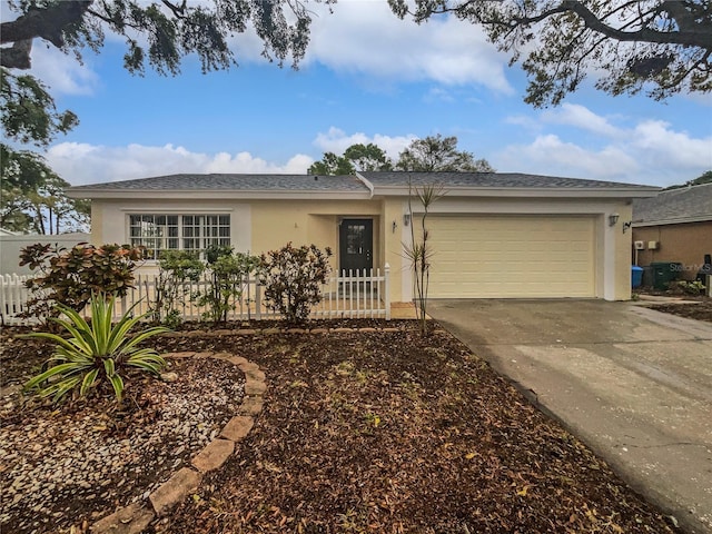 single story home with stucco siding, a garage, concrete driveway, and fence