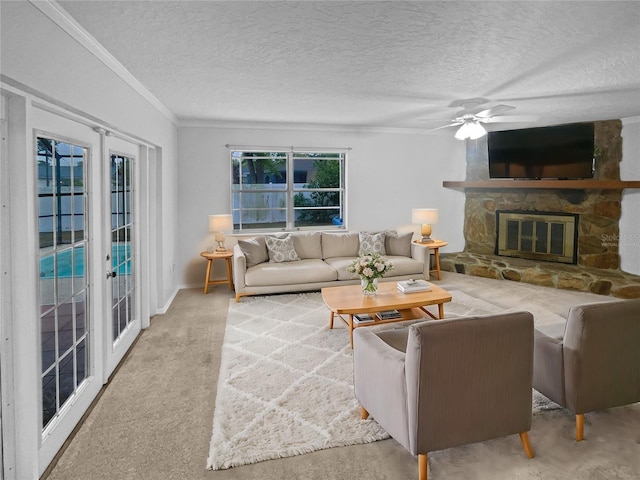 carpeted living room with a stone fireplace, ornamental molding, french doors, and a textured ceiling