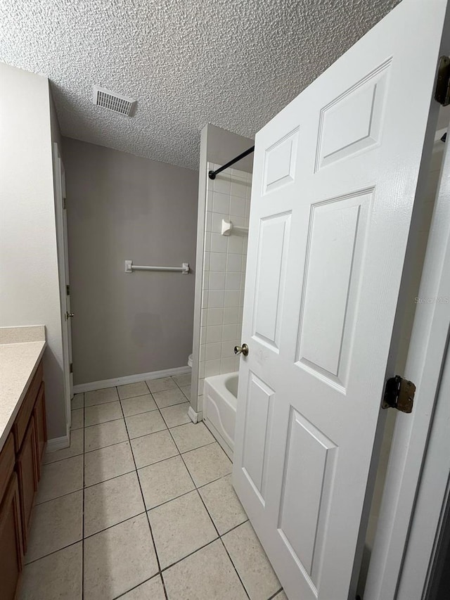 full bath with vanity, baseboards, visible vents, tile patterned flooring, and a textured ceiling