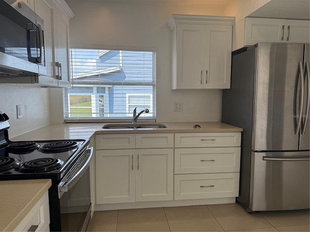 kitchen with a sink, appliances with stainless steel finishes, white cabinets, and light countertops