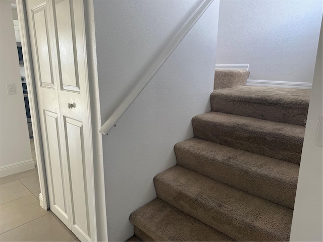 staircase featuring tile patterned flooring and baseboards