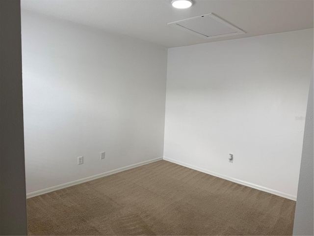 spare room with attic access, baseboards, and carpet floors