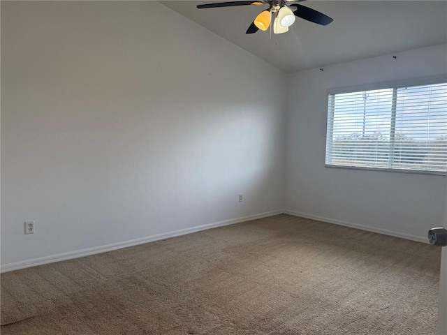 carpeted empty room featuring vaulted ceiling, a ceiling fan, and baseboards