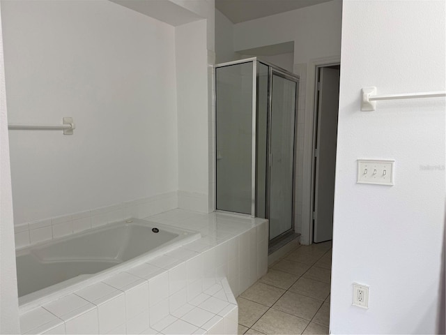 full bath with tile patterned floors, a bath, and a stall shower