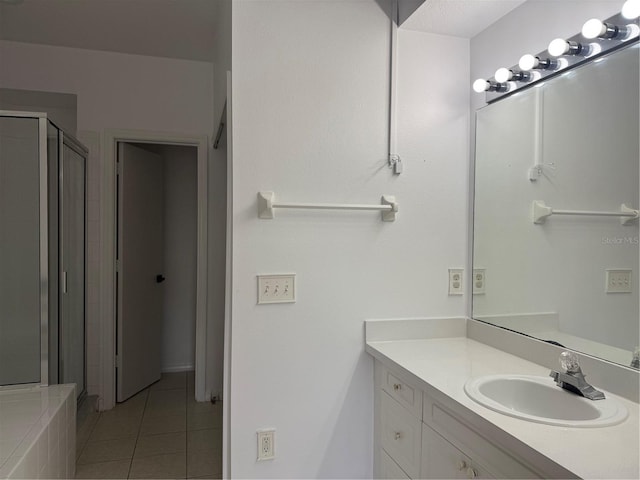 bathroom featuring tile patterned flooring, vanity, and a stall shower