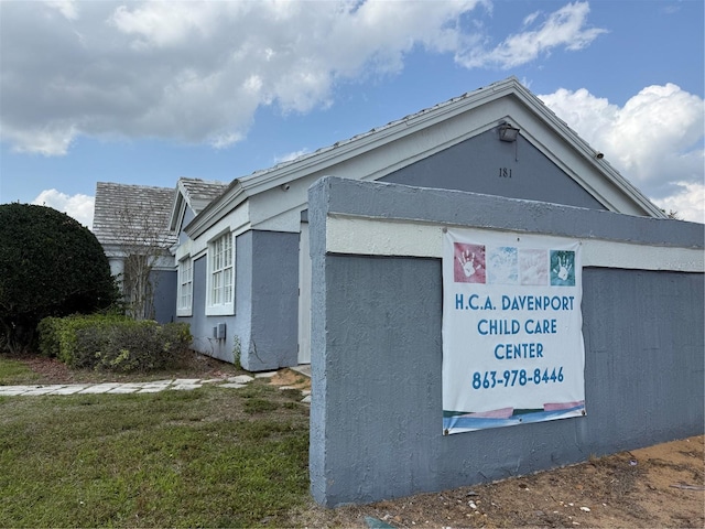 view of property exterior featuring stucco siding and a lawn