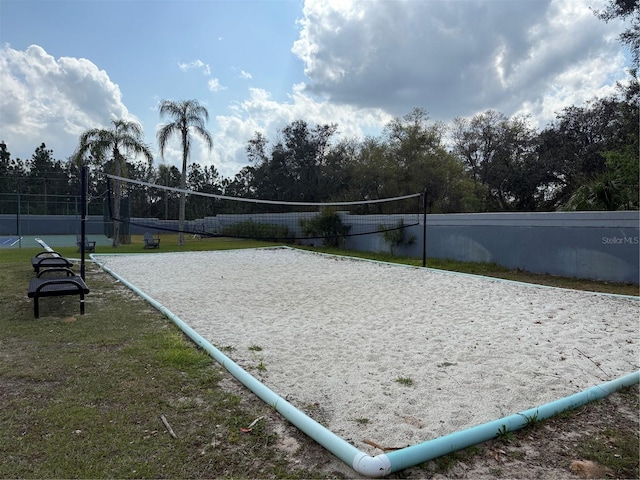 view of home's community with volleyball court, a yard, and fence