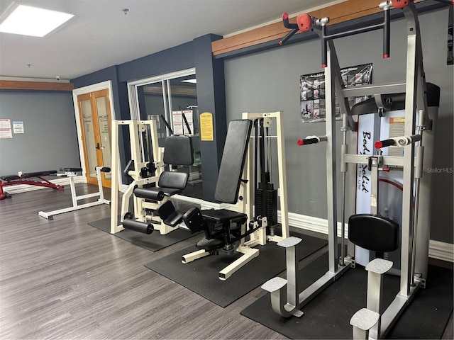 workout area with baseboards and wood finished floors