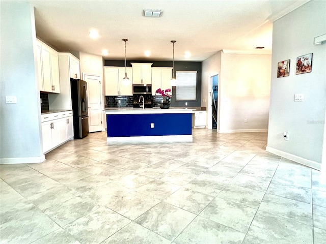 kitchen with visible vents, a kitchen island with sink, decorative backsplash, appliances with stainless steel finishes, and white cabinetry