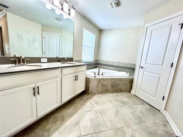 bathroom with a sink, visible vents, a garden tub, and double vanity