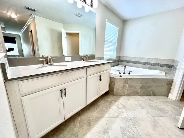 full bathroom featuring a garden tub, double vanity, visible vents, and a sink