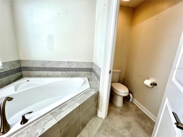 bathroom with a bath, toilet, and baseboards