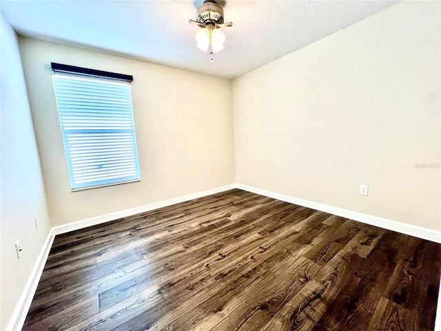 empty room featuring dark wood finished floors and baseboards