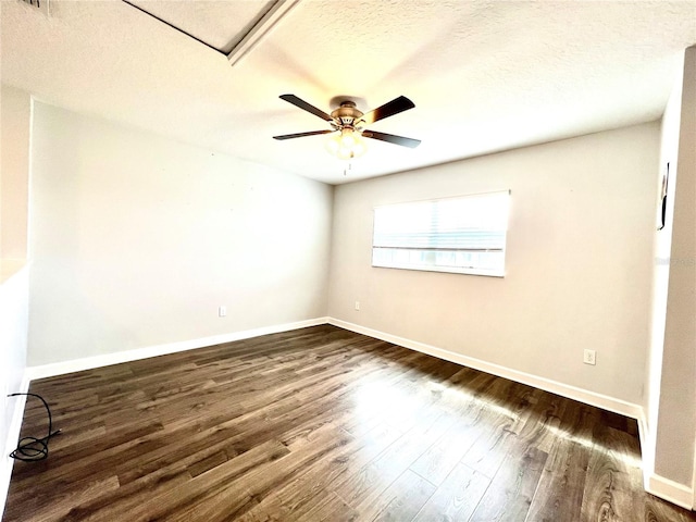 spare room with a textured ceiling, a ceiling fan, baseboards, and dark wood-style flooring