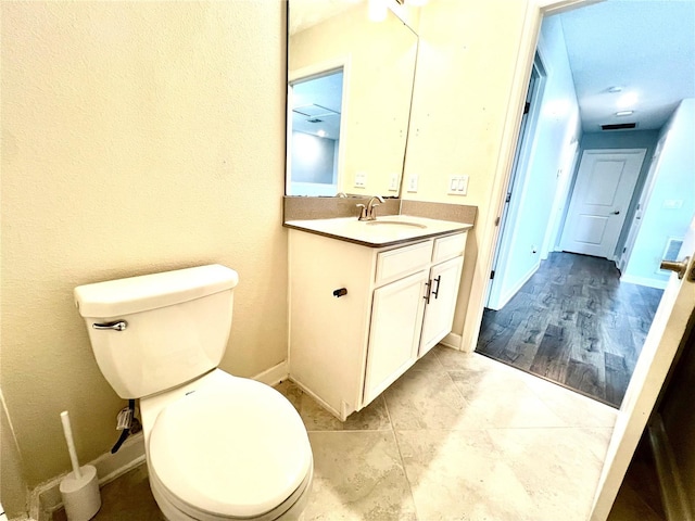 bathroom featuring vanity, toilet, and baseboards