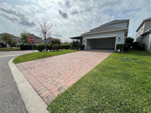 view of side of property with decorative driveway, a yard, an attached garage, and stucco siding