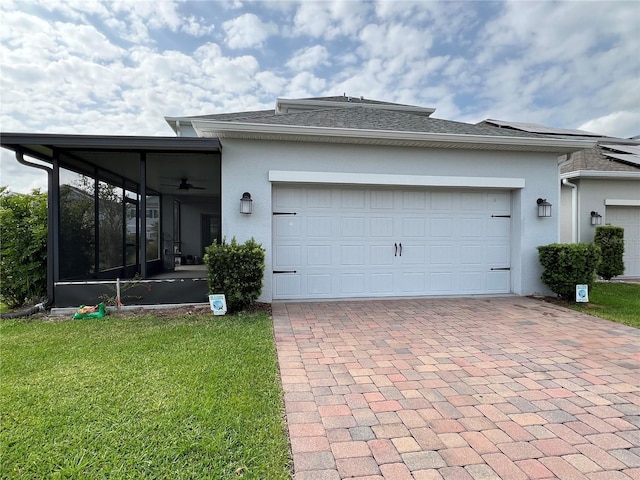 exterior space with an attached garage, decorative driveway, a sunroom, and stucco siding