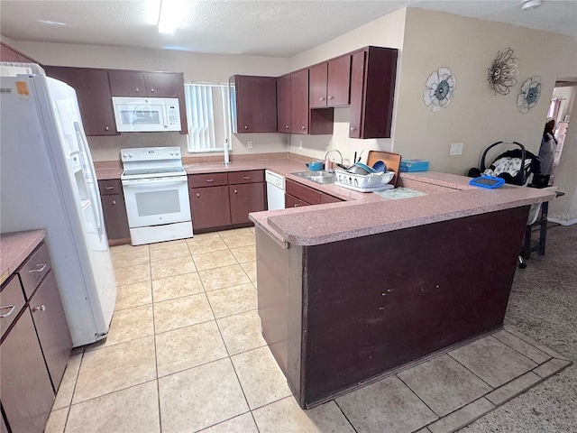 kitchen featuring a sink, white appliances, a peninsula, light countertops, and light tile patterned floors