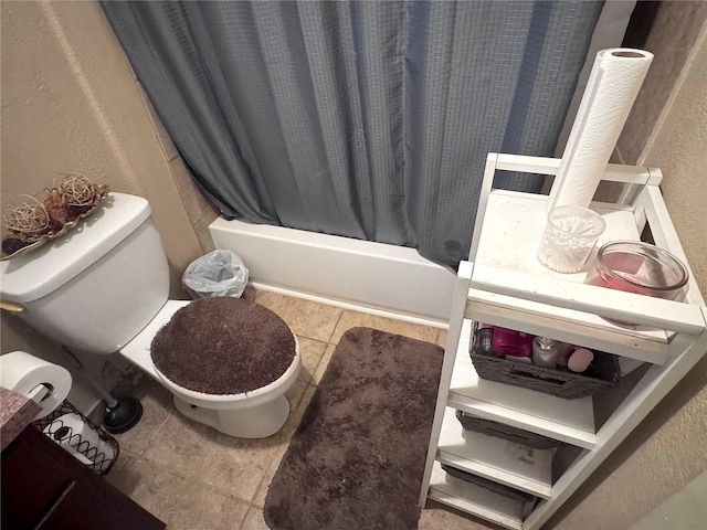 full bath featuring tile patterned floors, toilet, shower / tub combo with curtain, and a textured wall