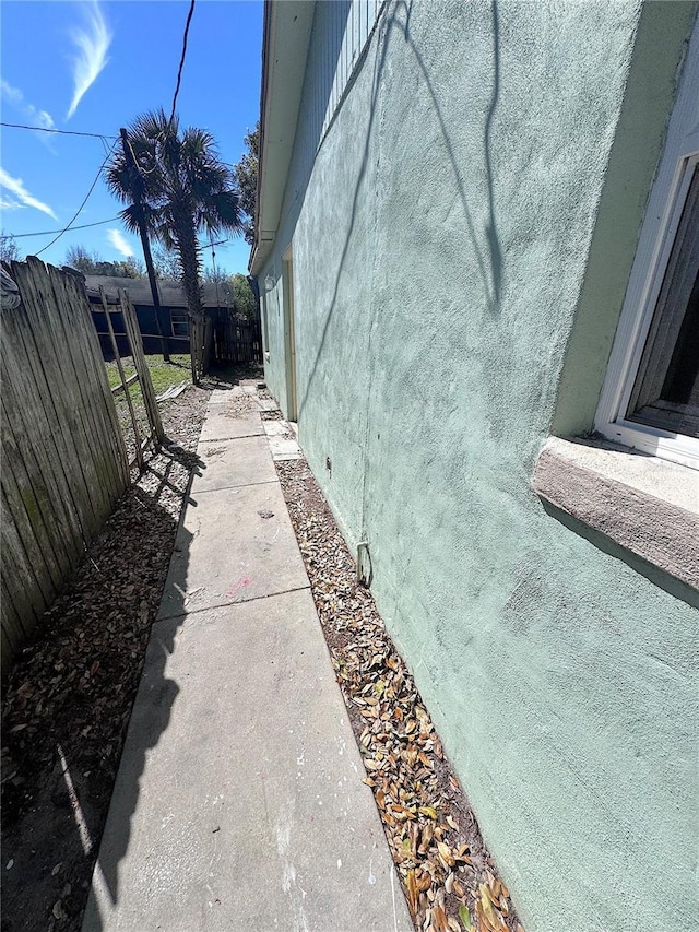 exterior space with crawl space, stucco siding, and fence