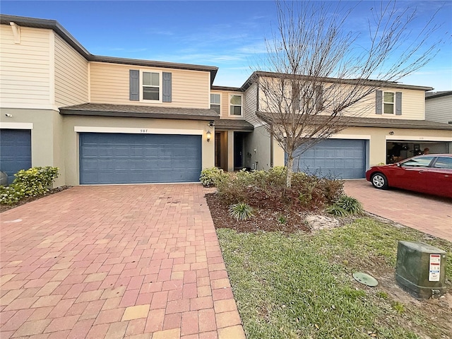 view of property with decorative driveway and stucco siding