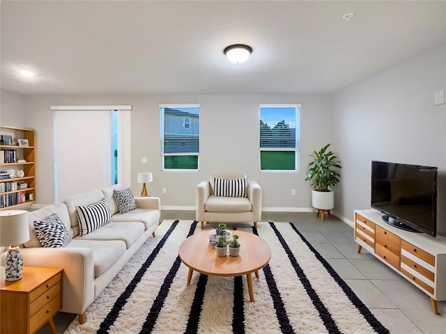 living area featuring baseboards and light tile patterned flooring